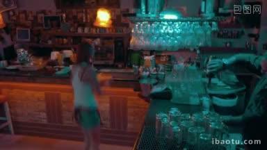 时间流逝的酒吧工作人员在工作酒吧男服务员在柜台上摆动灯和调制鸡尾酒女服务员正在为他们服务